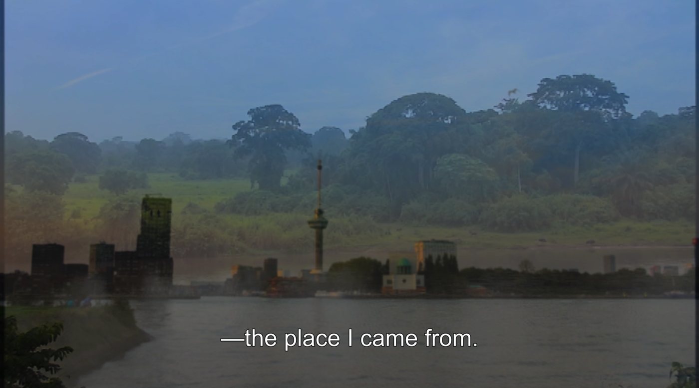 Film still: the Rotterdam skyline and Euromast across a river, blended with dense tropical forest; subtitle reads “—the place I came from.”